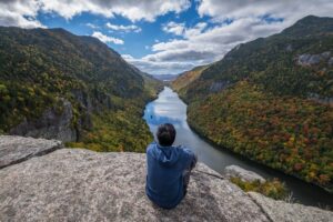 Ellicott guest sits on cliff along side a river