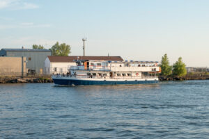 A tour boat sails around Buffalo New York while Ellicott Development lists the best boat tours in Buffalo