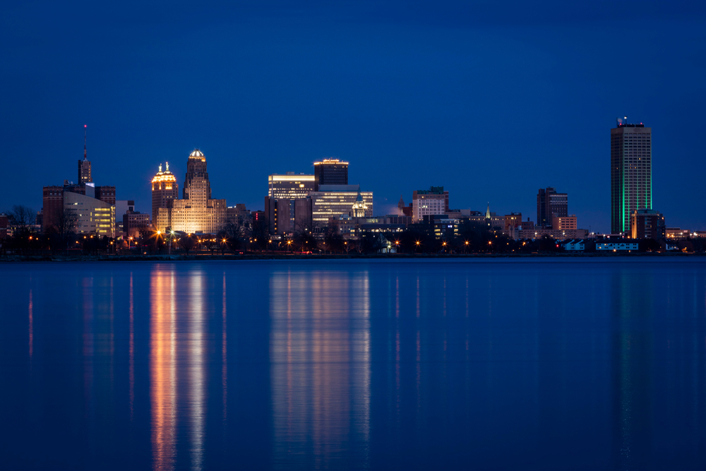 Buffalo waterfront skyline at night while Ellicott Development lists the best waterfrint restaurants