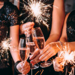 A group of people holding sparklers and flutes of champagne celebrate the new year in Buffalo, New York